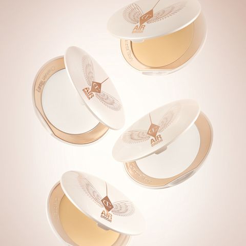 Una collezione di ciprie compatte fissanti aperte, in due tonalità, Fair to Light e Medium to Deep, con una confezione color bianco e oro.