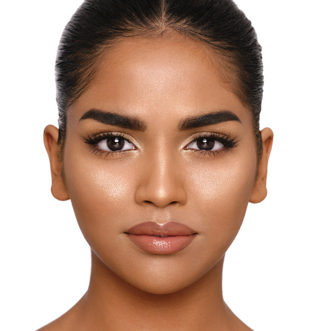 Medium-tone brunette model with brown eyes wearing a true gold powder highlighter with nude lipstick and black eyeliner.