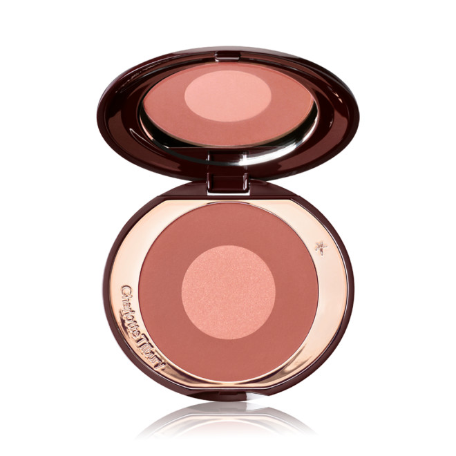 An open, two-tone, round blush with a pinky-brown outer circle and rose gold centre, encased in a metallic, rose gold case with a mirror inside the lid. 
