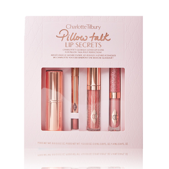 Lipstick in gold packaging, nude pink lip liner, nude pink glitter-free lip gloss, and glittery nude pink lip gloss packed in a nude pink box with Pillow Talk Lip Scerets written on it. 