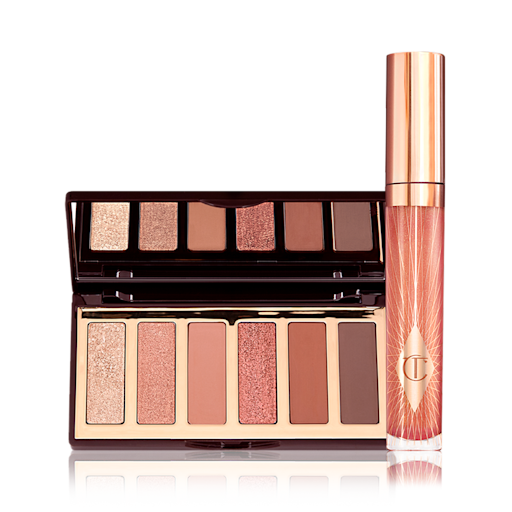 Charlotte Darling and Collagen Lip Bath Kit displayed An open, 6-pan, mirrored-lid, matte and shimmery eyeshadow palette with shades in brown, gold, and peach along with a high-shine, peach lip gloss in a glass tube with a gold-coloured lid.