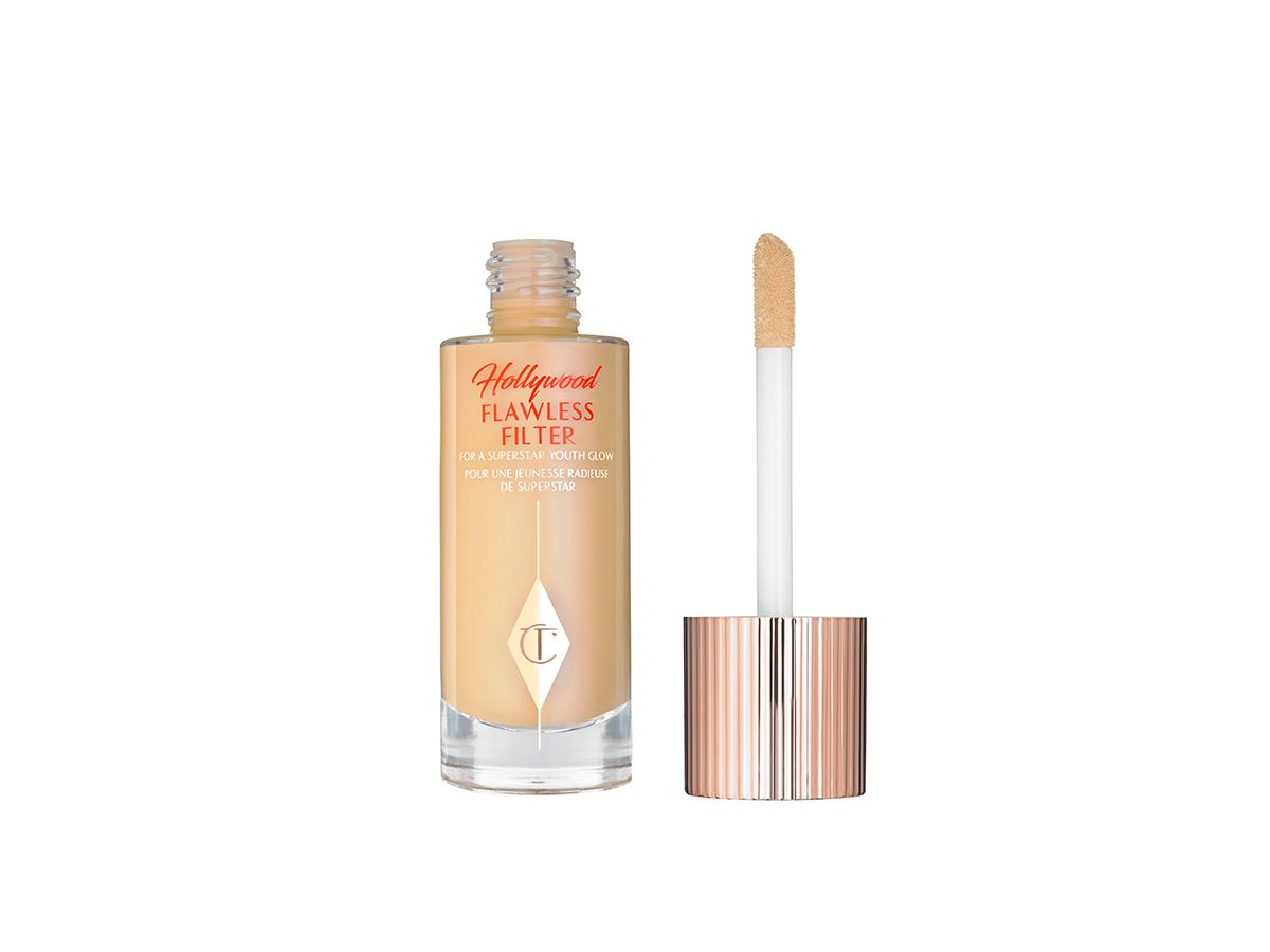 Hollywood Flawless Filter in shade open An open glow-boosting primer in a glass bottle with a rose gold-coloured lid with a doe-foot applicator.