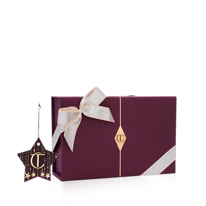 Holiday gift wrapping A maroon-coloured gift box with the CT logo printed on it, and the box adorned with a silver satin ribbon tied across with a bow on the top.