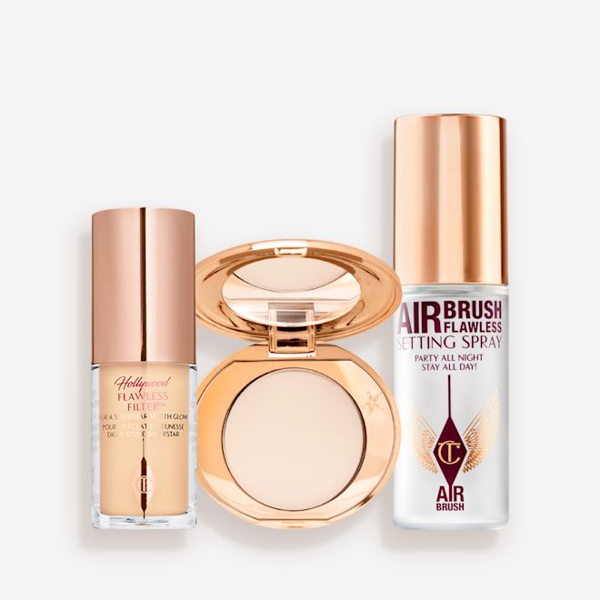 Hollywood Flawless Filter, Airbrush Flawless Finish, and Setting Spray Travel Size Kit Travel-size kit that includes a glowy primer in a glass bottle with gold-coloured lid, face powder compact in a light shade with a mirrored-lid in gold-coloured packaging, and setting spray in a clear bottle with gold-coloured lid.