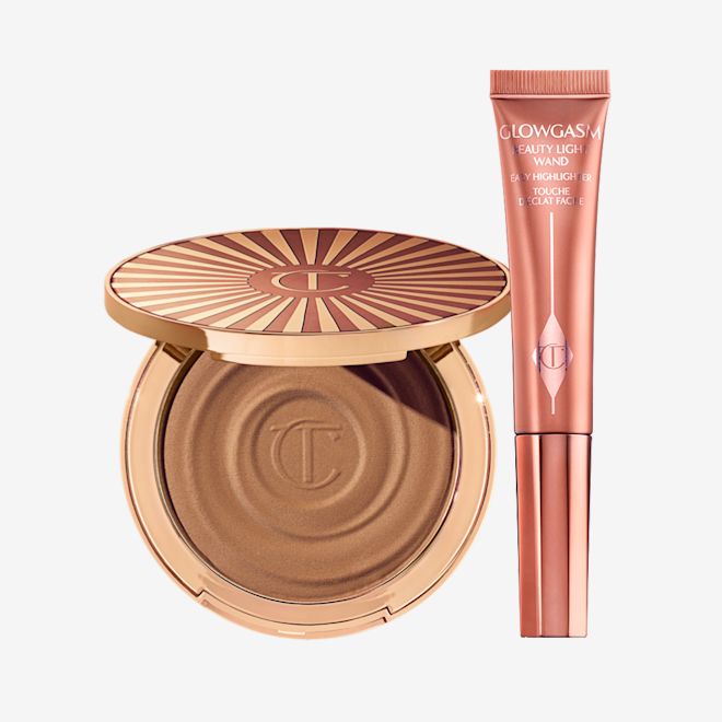 Beautiful Skin Sun-Kissed Radiant Bronzer and Beauty Light Wand An open cream bronzer compact with gold-coloured packaging with a highlighter blush wand in a medium-pink colour in sleek, reflective, medium-pink colour packaging.