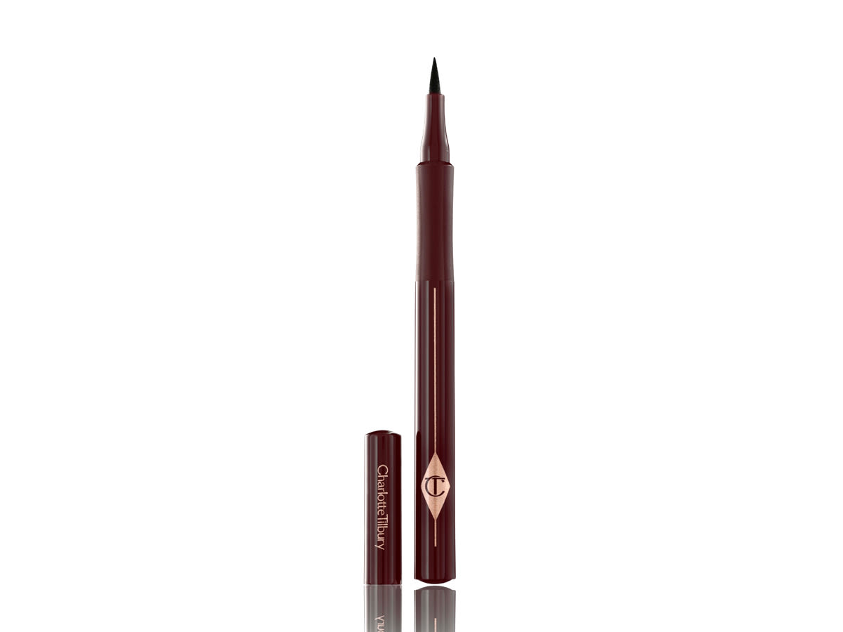 The Feline Flick Eyeliner in Super Brown open An eyeliner pen in a dark brown shade with dark crimson packaging with its cap next to it.