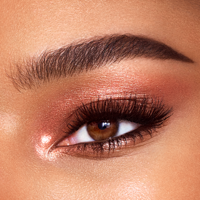 Eyes to Mesmerise in Copper Sunrise on brown eye close-up Single-eye close-up of a model with brown eyes with shimmery, coppery-gold-coloured cream eyeshadow.