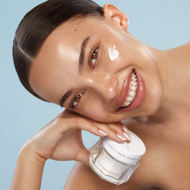 Smiling model holding Magic Water Cream