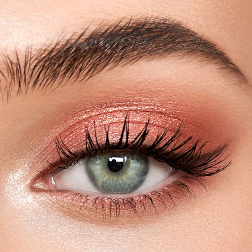 Eyes to Mesmerise in Pillow Talk on fair-tone model eye close-up Single-eye close-up of a fair-tone model with blue eyes wearing shimmery rose gold eyeshadow.