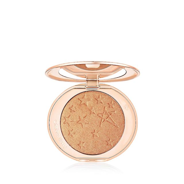 Hollywood Highlighter in Sunset Glow open An open highlighter powder compact with a mirrored lid, in a shimmery copper-gold shade.