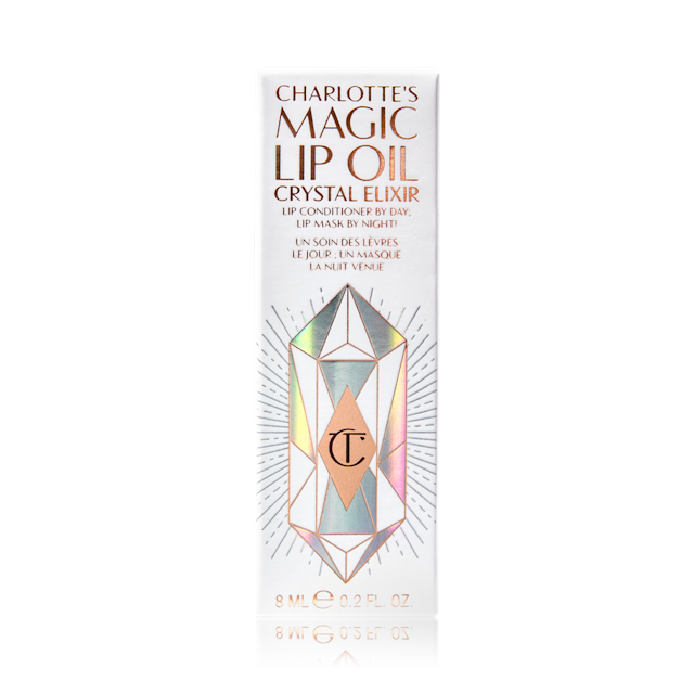 Charlotte's Magic Lip Oil Crystal Elixir packaging A white-coloured lip oil box with shiny, geometric patterns on it, and Magic Lip Oil written on it in rose gold colour.