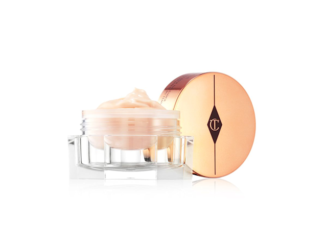 Magic Eye Rescue open An open, light champagne-coloured eye cream in a glass pot with its rose-gold-coloured lid next to it.