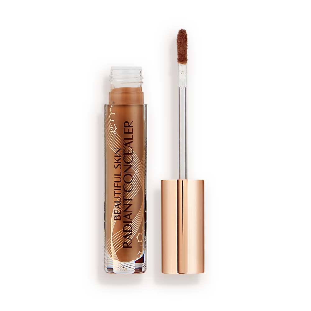 Beautiful Skin concealer in 15 open Dark brown radiant concealer in a glass tube with its gold-coloured lid with a doe-foot end next to it, and text on the tube that reads, 'Beautiful Skin Concealer'