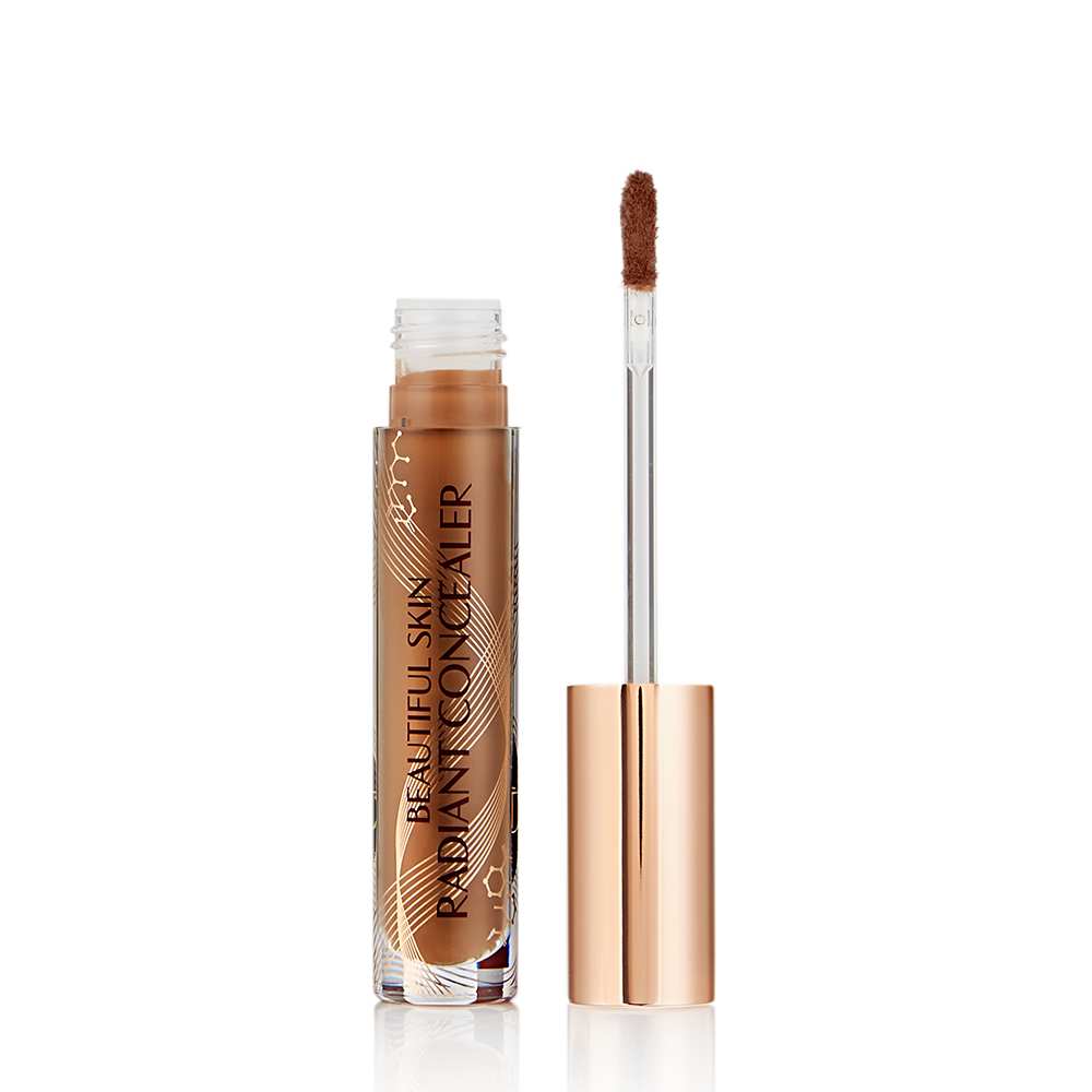 Beautiful Skin Concealer in Farbton 15, geöffnet Dunkelbrauner, strahlender Concealer in einem Glasfläschchen mit dem Text „Beautiful Skin Concealer“ und daneben seine goldfarbene Kappe und sein angeschrägter Applikator.