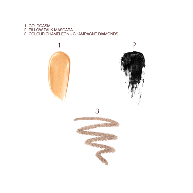 Charlotte's Power Glow Kit swatches Swatches of liquid highlighter in a soft gold shade, black mascara, and eyeshadow stick in a champagne shade.