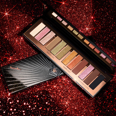 Red and black-coloured galaxy-theme banner with an open and closed, 12-pan eyeshadow palette with matte and shimmery shades in beige, pink, gold, green, brown, peach, and black, with text on the banner that reads, 'New! instant eye palette smokey eyes are forever. Shop now'
