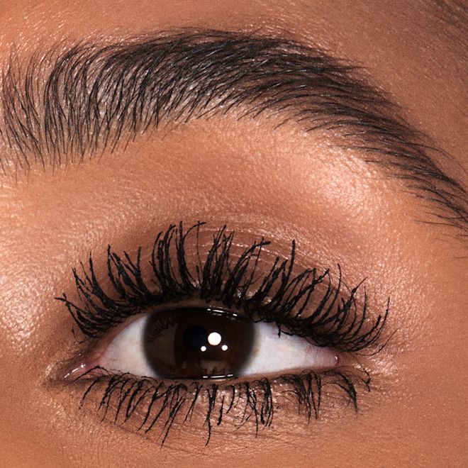4x3 Pillow Talk Push Up Lashes Model Après Single-eye close-up of a deep-tone model with brown eyes wearing jet-black lengthening mascara.