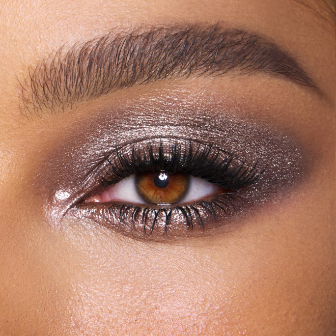 Close-up of a model with brown eyes wearing iridescent smokey grey eyeshadow with very fine shimmer. 