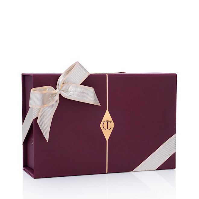 Holiday Gifting sleeve large Minimalistic, maroon-coloured gift box for makeup and skincare items with glossy ivory-coloured ribbons wrapped around it.
