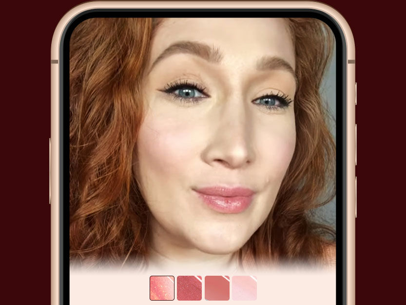 Virtual try-on lip gloss banner fair-tone model with blue eyes wearing black eyeliner, nude pink blush, and glowy, high-shine lip gloss showing how different lip glosses look on her.