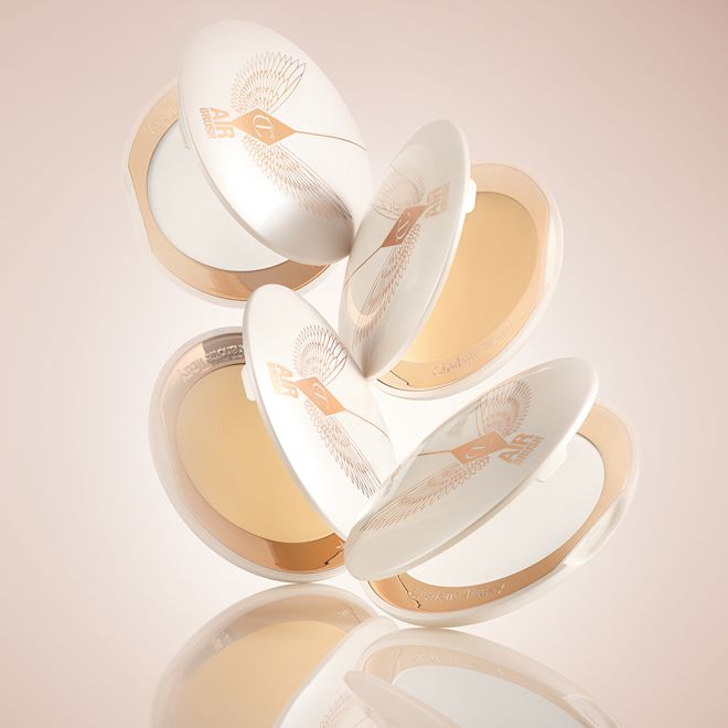 Brightening Airbrush Flawless Finish compacts open A collection of open, setting powder compacts in two shades, fair to light and medium to deep, in white and gold-coloured packaging.