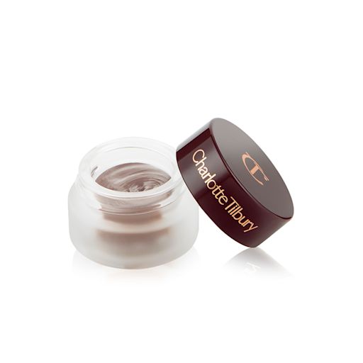 Eyes to Mesmerise in Smokey Taupe open An open frosted glass pot with a cream eyeshadow in a smokey taupe shade with a matte finish with a dark brown lid with Charlotte Tilbury written on the lid in gold.