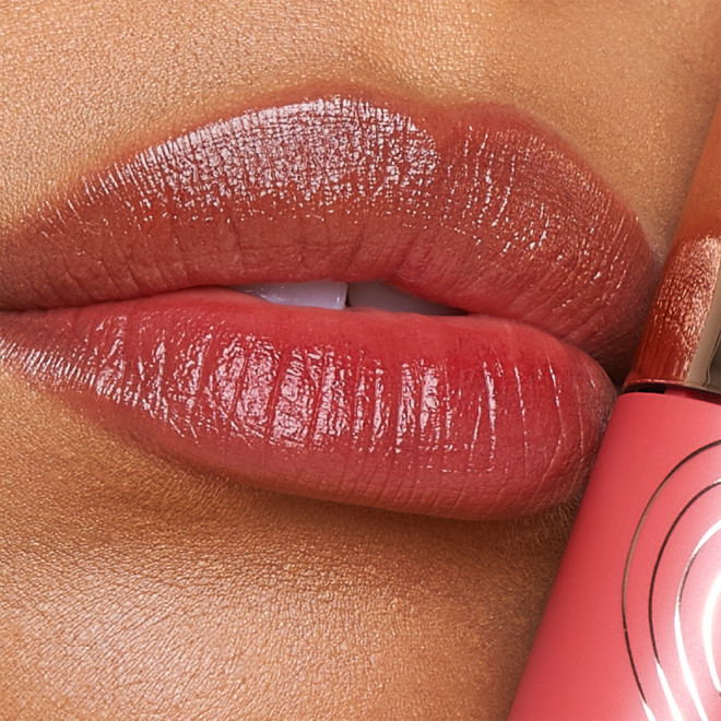 Lips close-up of a medium-tone model wearing a soft, peachy-brown lip tint.