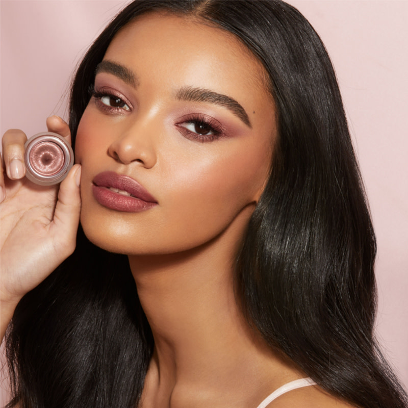 Deep-tone model with brown eyes wearing berry-rose lipstick with a russet rose cream eyeshadow with a golden-peach sparkle.