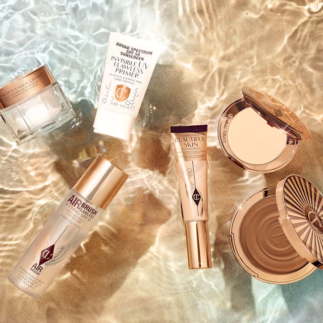 011 210582 BEAUTIFUL SKIN BRONZER SL BS BRONZER NA ROUTINE JB 2203 Setting spray in a clear bottle with a gold-coloured lid, highlighter wand in a golden-coloured tube with a gold-coloured lid, bronzer compact with a mirrored-lid, face cream in a glass jar, setting powder compact, and an SPF-infused primer in a white tube.