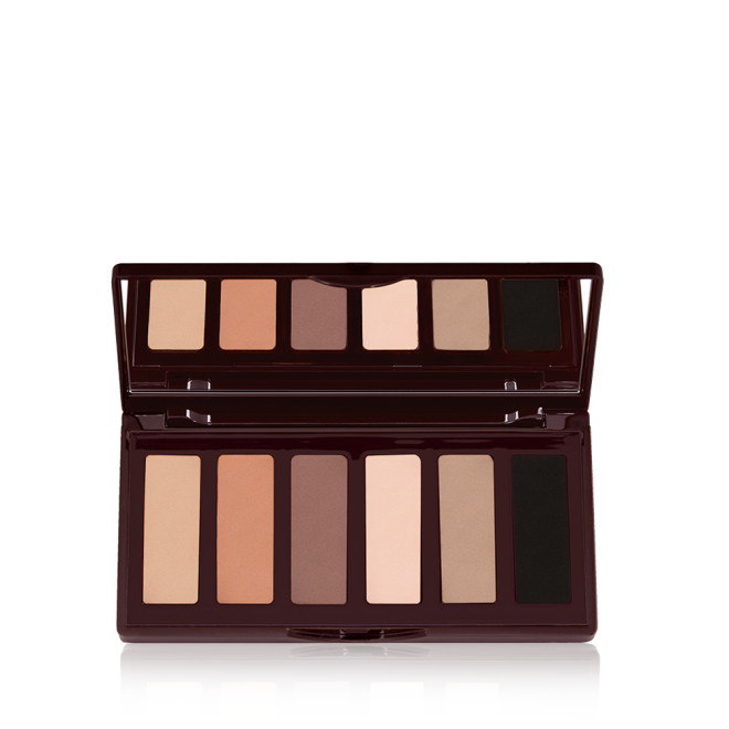 An open, mirrored-lid six-pan eyeshadow palette with matte eyeshadows in brown, peach, and beige shades.