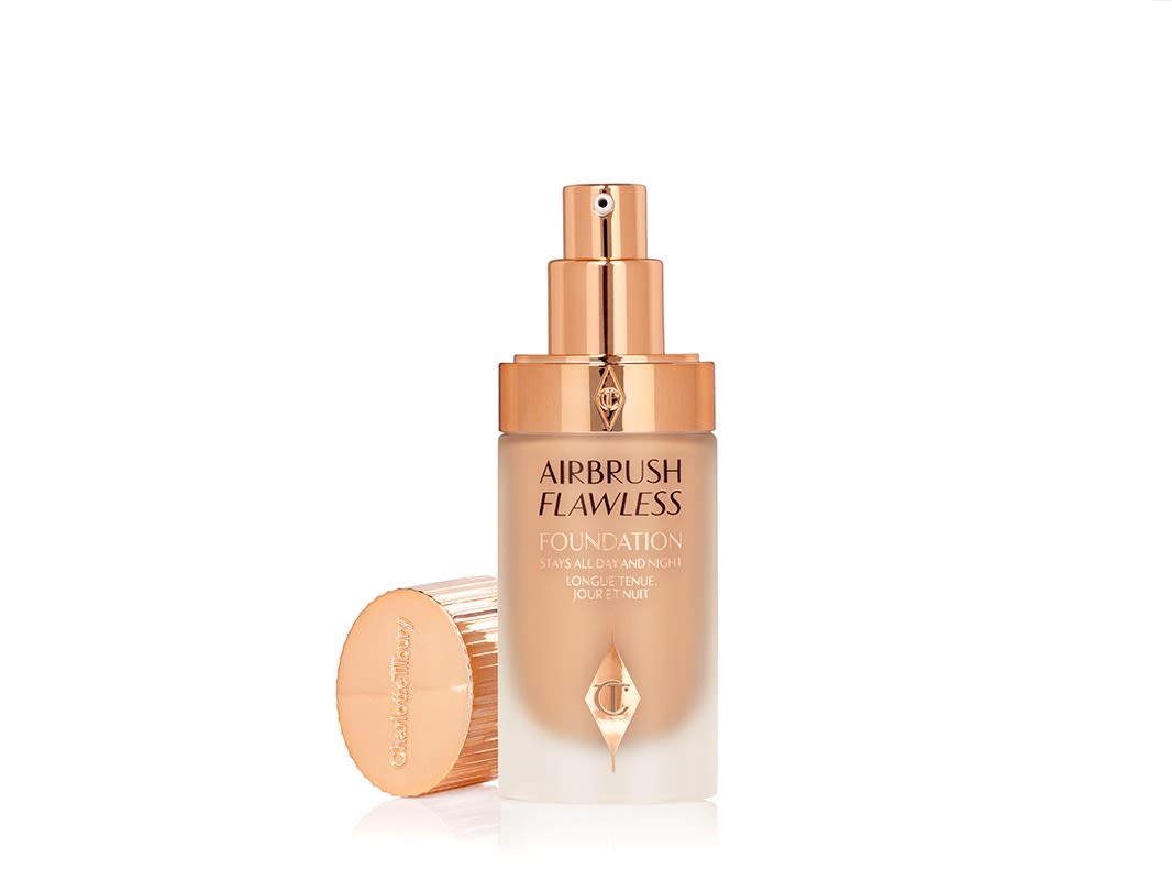 Airbrush Flawless Foundation open An open, warm beige coloured-foundation in a frosted glass bottle in clear and rose-gold packaging with its metallic lid next to it.