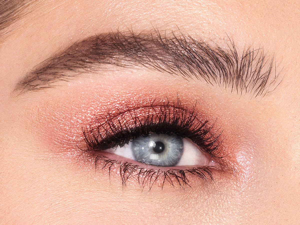 Jewel Pots in Pillow Talk on fair-tone model with brown eyes Single-eye close-up of a fair-tone model with blue eyes wearing shimmery rose gold eyeshadow.
