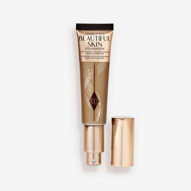Beautiful Skin Foundation in Shade 9N open An open foundation wand in gold packaging with a pump dispenser and a medium-dark-brown-coloured body to show the shade of the foundation inside.