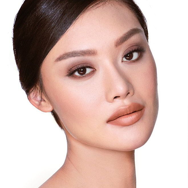 The Sophisticate look on fair-tone model A fair-tone model with brown eyes wearing smokey brown eye makeup with muted pink blush with glossy soft-brown lips.