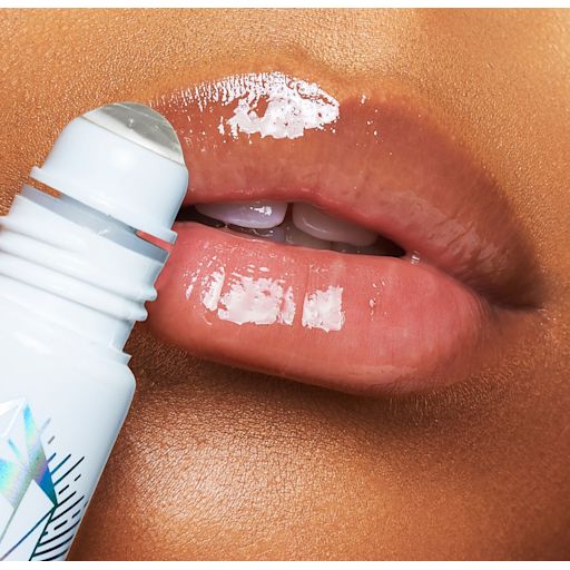 Magic Lip Oil Crystal Elixir on deep-tone model lips close-up Close-up of a deep-tone model applying a nourishing, clear lip oil with a crystal roller ball applicator.