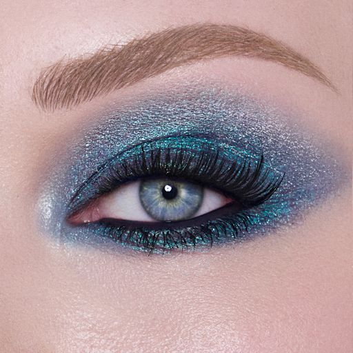 Hypnotising Pop Shot in Cosmic Rocks on brown eye close-up Close-up of a model with blue eyes wearing iridescent duo-chrome purple and teal eyeshadow with very fine shimmer.