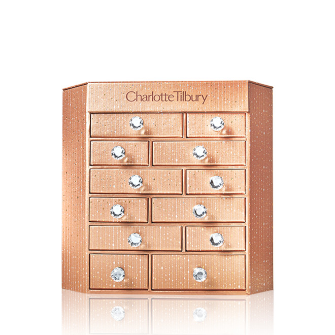 A golden-coloured chest of drawers with Charlotte Tilbury written on top. 