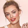 Quick & Easy Instant 5 Minute Pretty Fresh Look on fair-tone model Fair-tone model with blue eyes wearing shimmery champagne pink eyeshadow with vivid coral blush and lip stain, and dewy opal-coloured highlighter for a fresh, glowing makeup look.