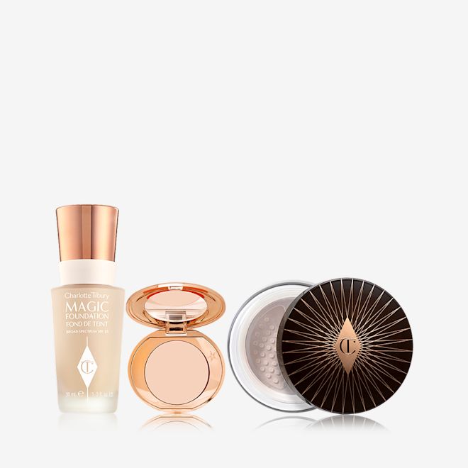 Charlotte's Magic Complexion Secrets displayed Foundation in a glass bottle with a gold-coloured lid, colour corrector compact in a light shade with a mirrored-lid, and loose setting powder with a black and gold-coloured lid.