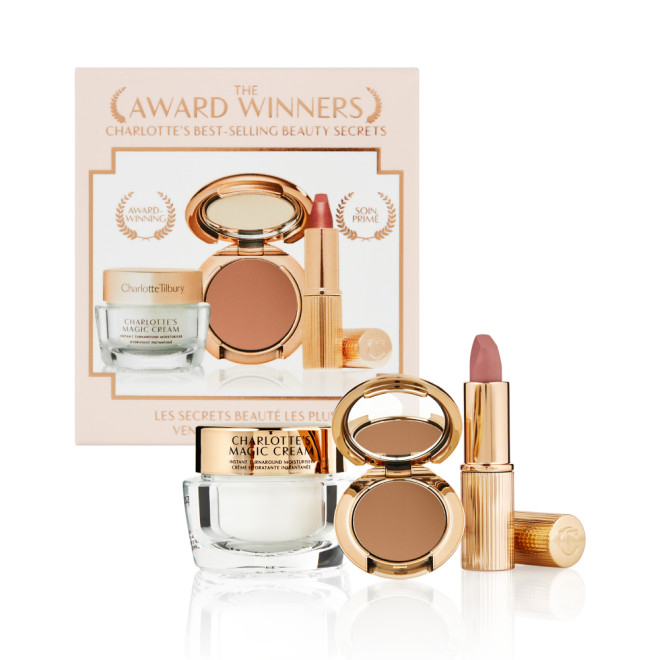 Pearly-white face cream in a glass jar with a gold-coloured lid, pressed powder compact in a dark brown shade, and a dusky pink lipstick in a sleek gold-coloured tube.