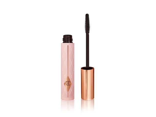 Pillow Talk Push Up Lashes! Mascara open Mascara in a pink-coloured tube with its gold-coloured lid with a black applicator next to it.