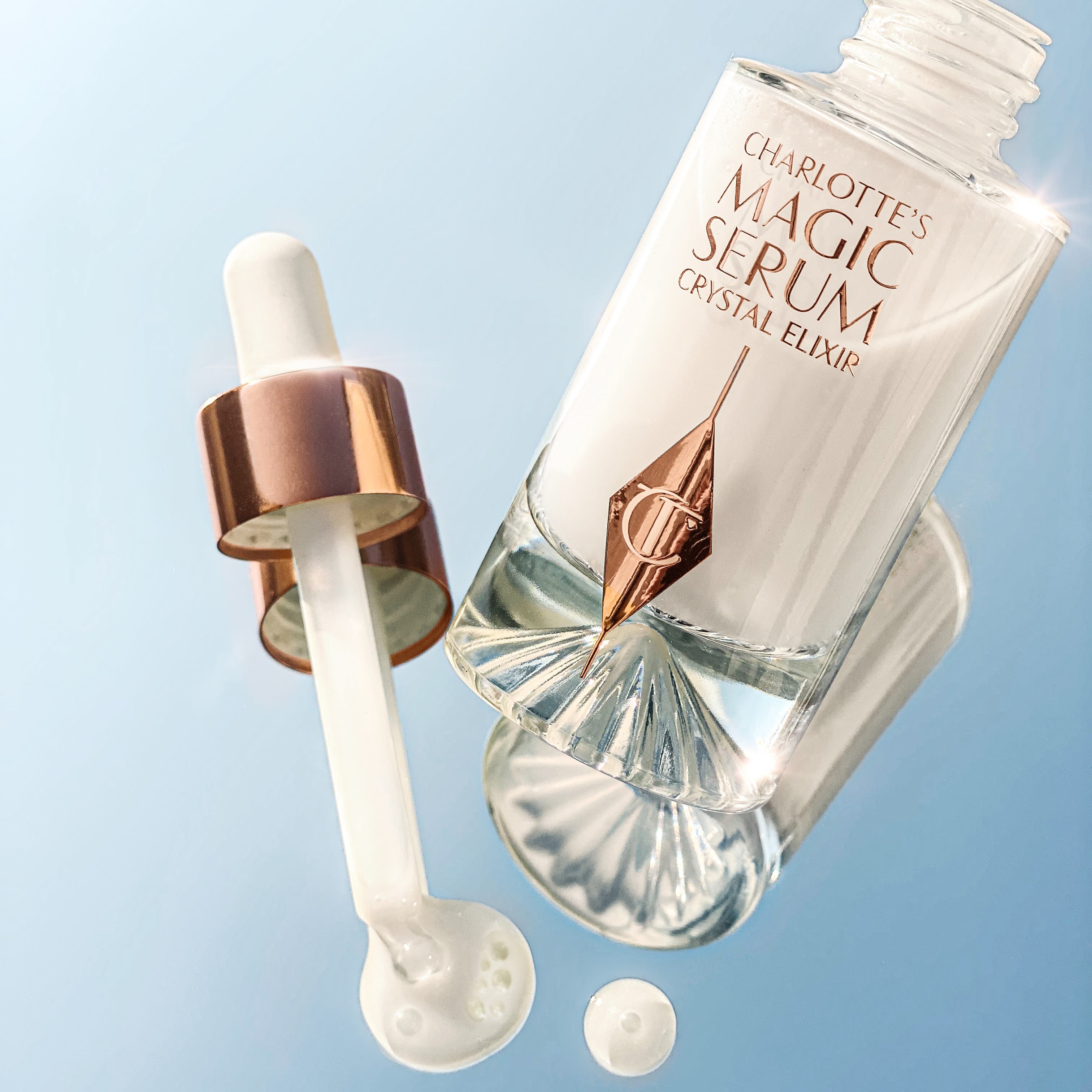Magic Serum open still life Charlotte's Magic Serum Crystal Elixir releasing drops of face serum
