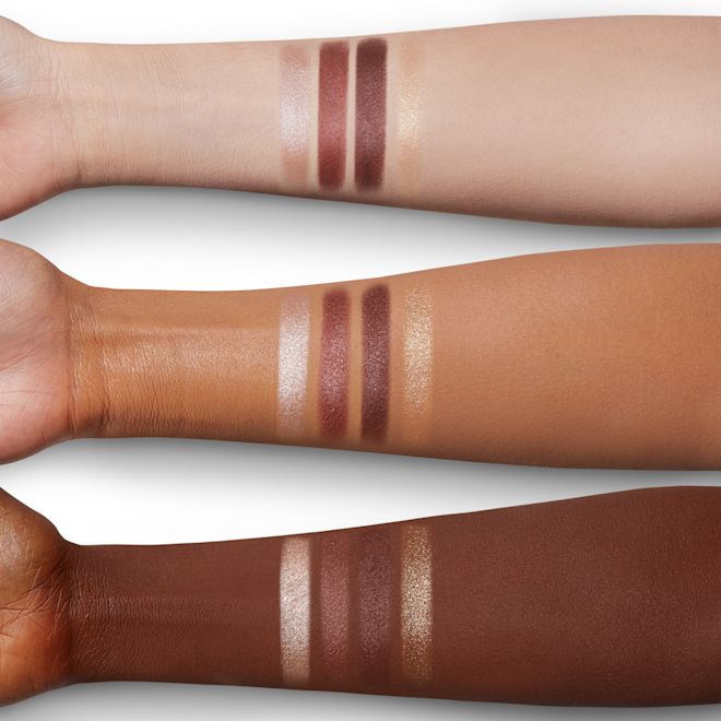 Luxury Palette in The Vintage Vamp arm swatches Arm swatches of four matte and shimmery eyeshadows in purple, nude, and golden colours on fair, tan, and deep skin.