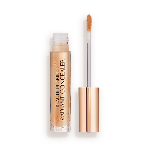Beautiful Skin Radiant in Concealer in 9.5 lid removed Radiant concealer in a glass tube with its doe-foot applicator next to it with a gold-coloured handle.