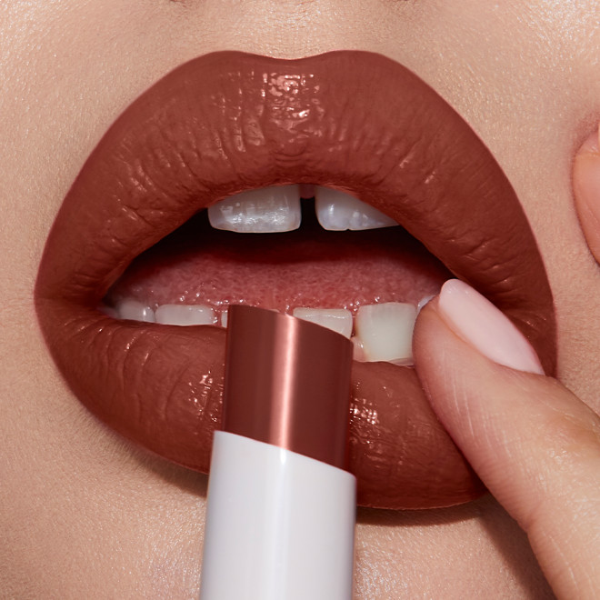 Lips close-up of a light-tone model wearing a moisturising lipstick balm in a soft brown shade.