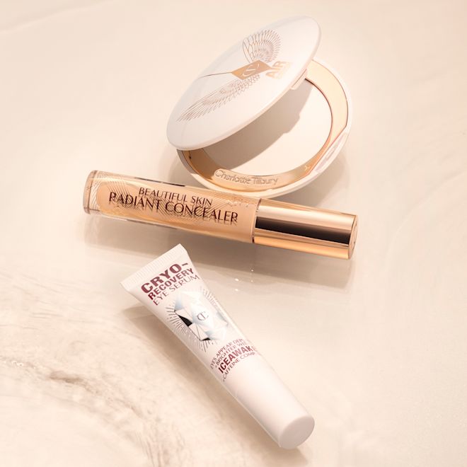 Wide Awake Eyes Kit Eye serum in a white-coloured tube, a brightening, setting powder compacts in white with white packaging, and a concealer in a glass tube and gold-coloured lid.