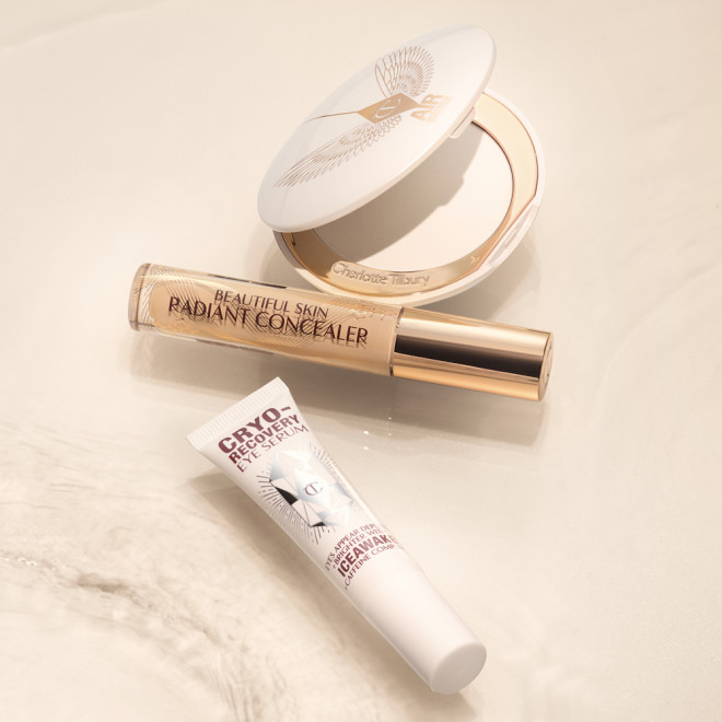 Eye serum in a white-coloured tube, a brightening, setting powder compacts in white with white packaging, and a concealer in a glass tube and gold-coloured lid.