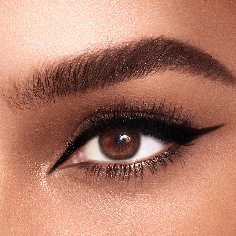 Eye close-up of a model with brown eyes wearing black winged eyeliner.