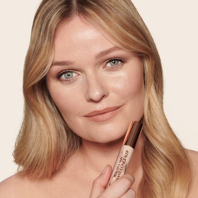Fair-tone model with blue eyes wearing a radiant, concealer that brightens, covers blemishes, and makes her skin look fresh along with nude lip gloss and subtle eye makeup.