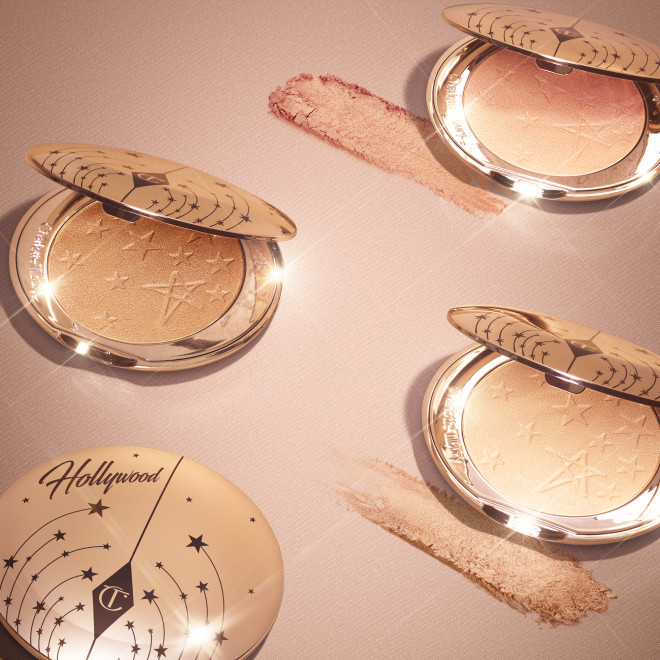Collection of open, powder highlighter compacts in shades of gold, brown, pink, and silver in sleek, golden-coloured lids.